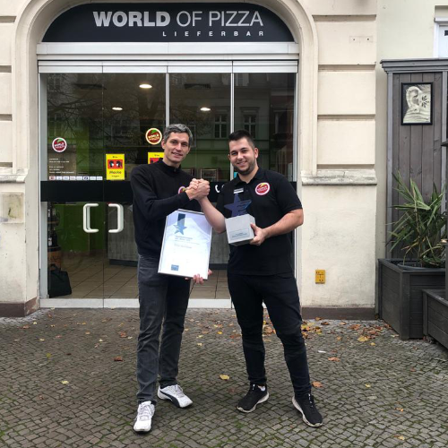Zwei Männer stehen vor einer Welt voller Pizza.